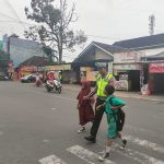 Wujud Kepedulian, Anggota Sat Lantas Polres Metro Bantu Anak Sekolah Menyebrangkan Jalan