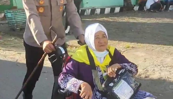 Kapolsek Pattallassang Bantu Dorong Kursi Roda Jamaah Haji Lansia